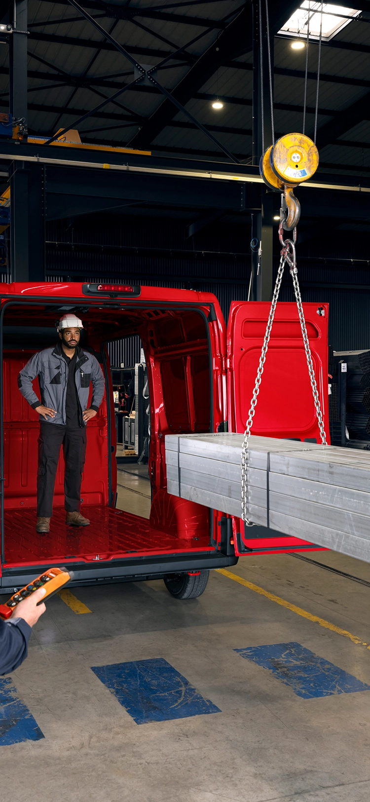 Zijaanzicht van een rode Citroën Jumper in een werkplaats, met nadruk op robuust design en professioneel gebruik.
