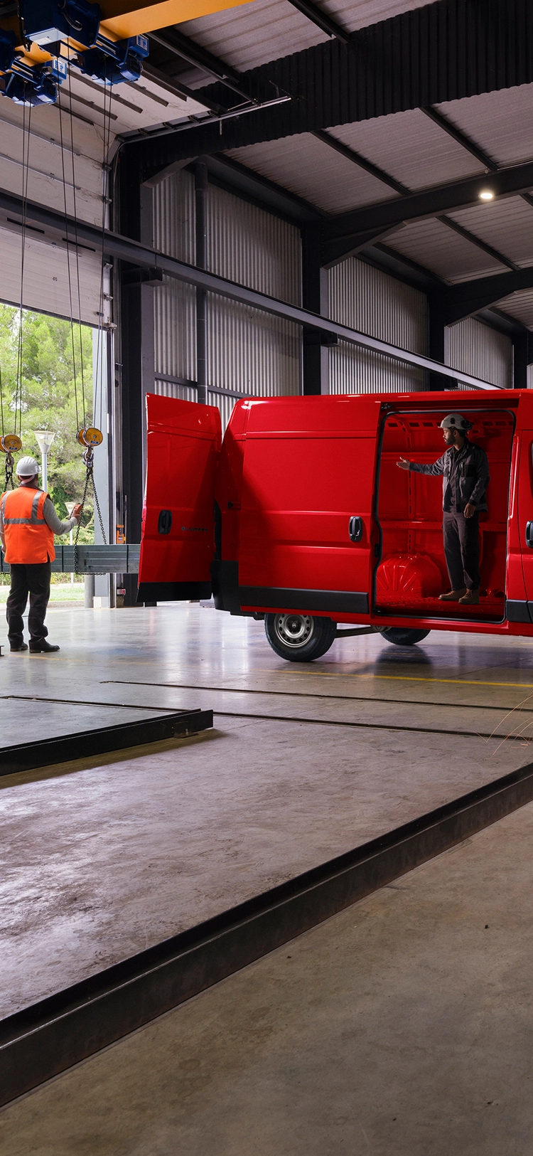 Zijaanzicht van een rode Citroën Jumper in een werkplaats, met nadruk op robuust design en professioneel gebruik.