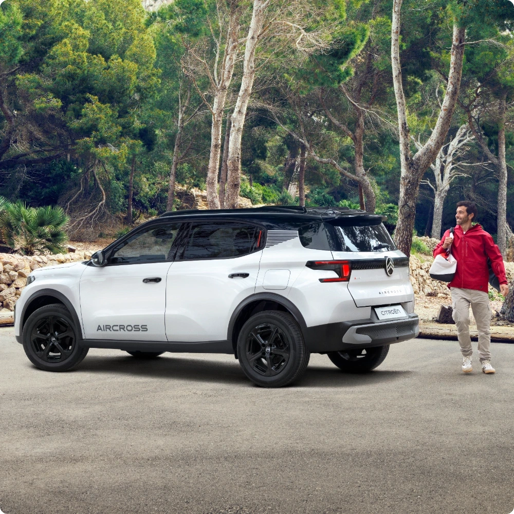 Driekwart achteraanzicht van de Citroën C3 Aircross Hybrid SUV rijdend in de buitenlucht, met efficiënte hybride technologie voor soepel, zuinig en betaalbaar dagelijks gebruik.