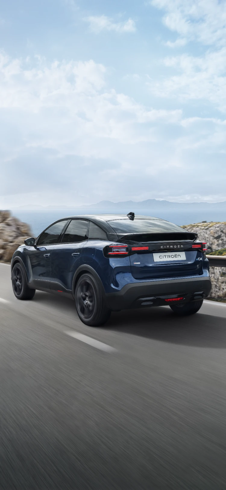 Driekwart achteraanzicht van de Citroën ë‑C4 rijdend, met aerodynamisch crossover‑design, efficiëntie en stijl voor een moderne, premium uitstraling.
