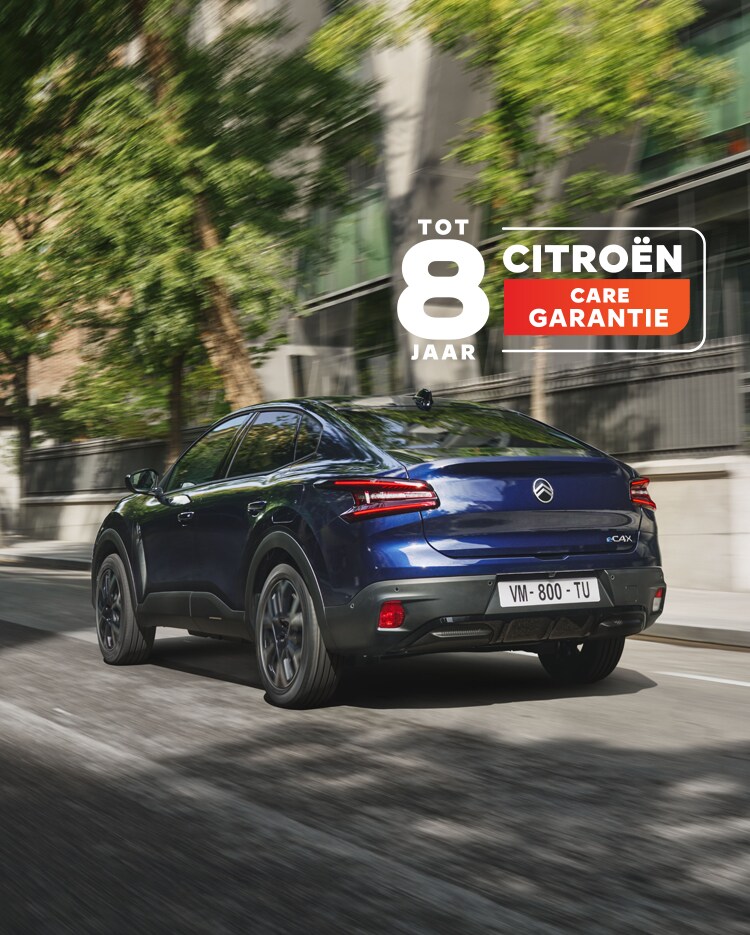 De Citroën ë‑C4 X rijdend op een weg met zichtbaar Citroën 8‑jaar garantie‑badge.